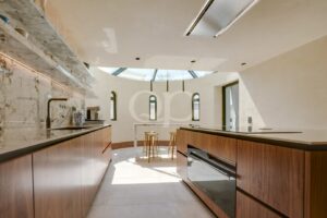 Open plan kitchen with marble finishes, skylight and central island