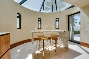Kitchen breakfast bar with marble finishes, high ceilings and arched windows