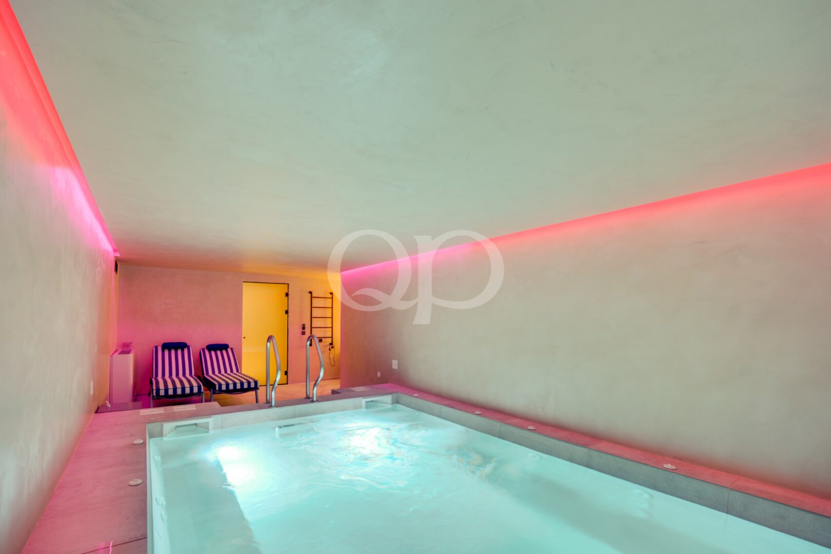 Indoor swimming pool with ambient lighting and dedicated relaxation area