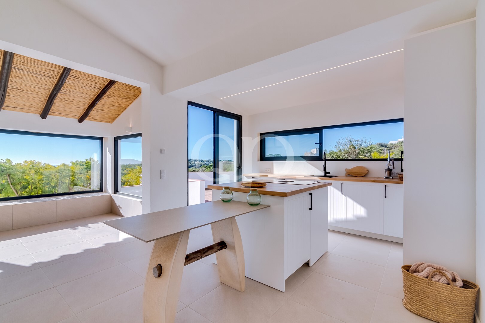 Bright contemporary kitchen with island, wooden worktops and large windows