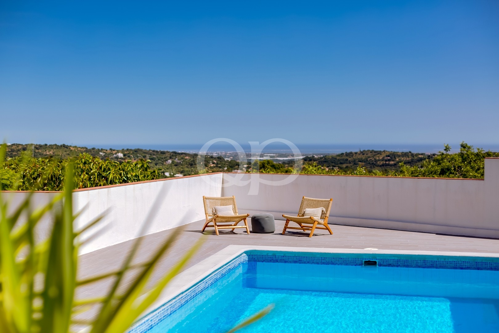 Private pool terrace with seating and panoramic countryside views
