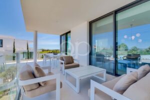 Terrasse privée couverte avec coin salon extérieur et vue sur les jardins paysagers