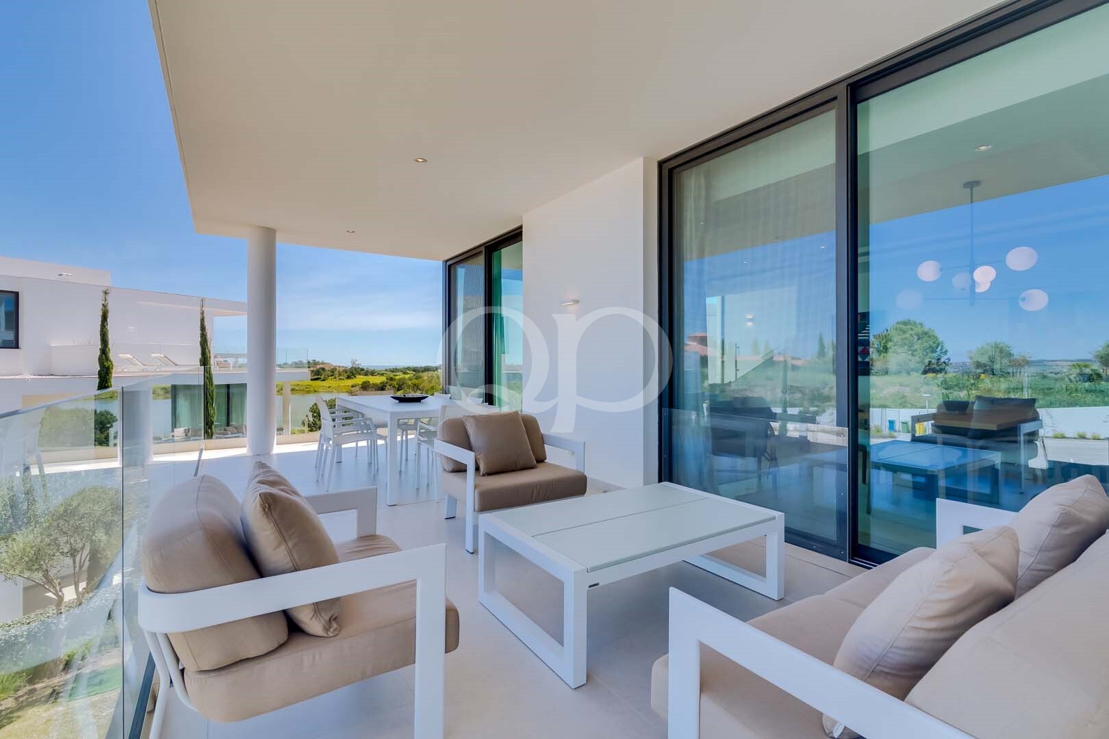 Terrasse privée couverte avec coin salon extérieur et vue sur les jardins paysagers