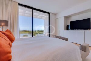 Chambre dotée de baies vitrées donnant sur un parcours de golf paysager