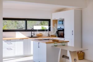 Modern fitted kitchen with breakfast bar, integrated appliances and countryside views