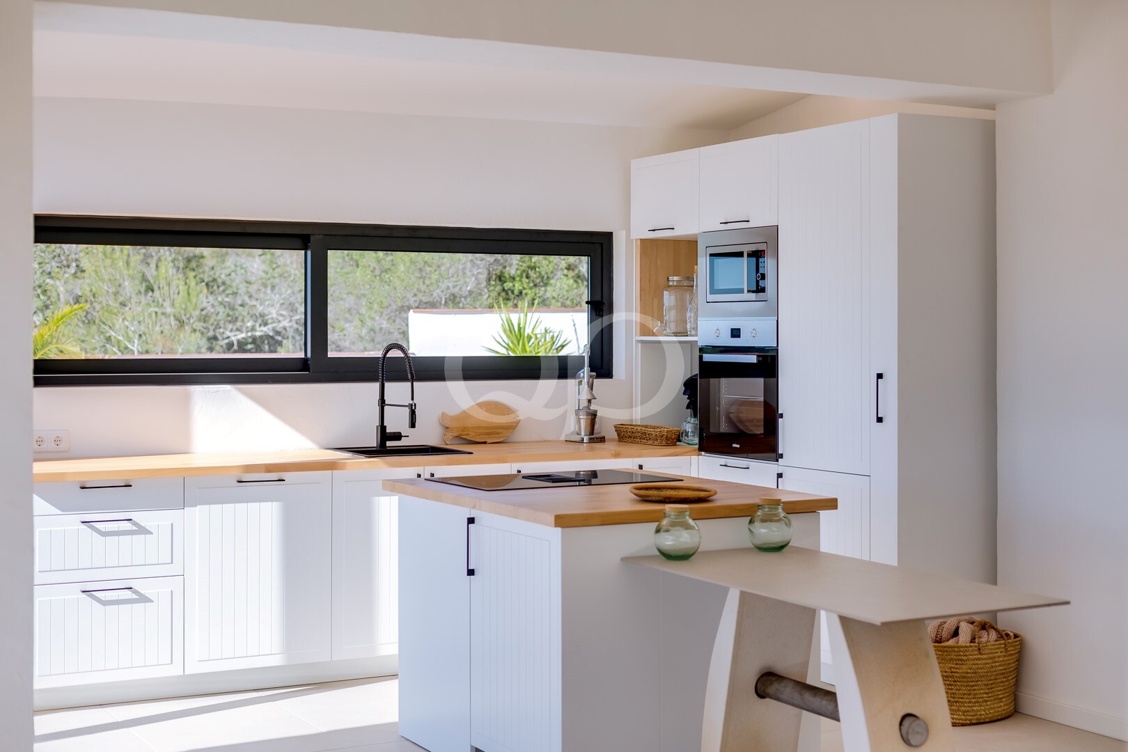 Modern fitted kitchen with breakfast bar, integrated appliances and countryside views