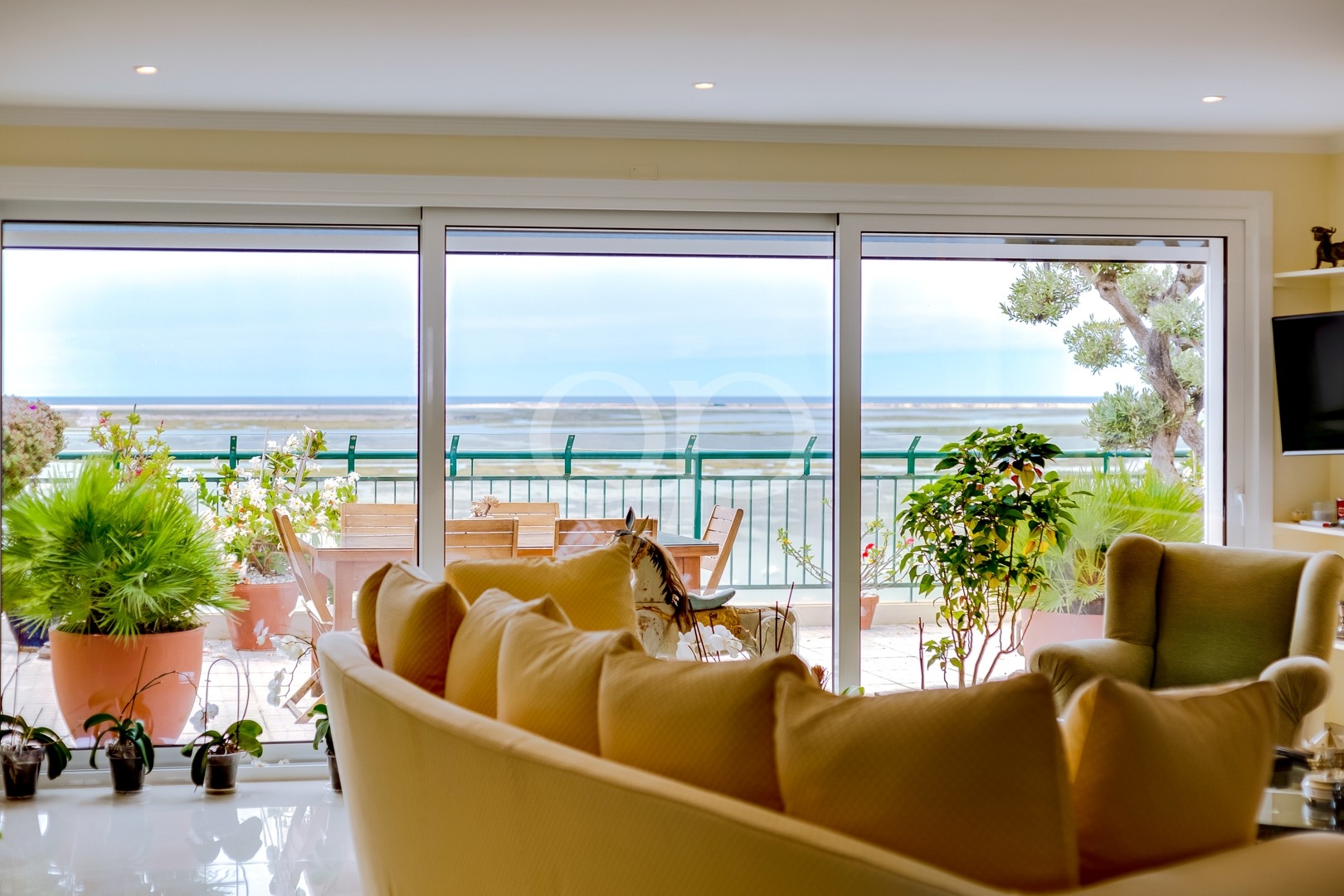 Sala de estar acolhedora que dá para um terraço com vistas espetaculares sobre a costa