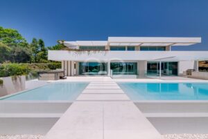 Moderne Villenfassade mit Swimmingpool und zentralem Steg aus Trittsteinen