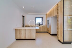 Kitchen with island, wood cabinetry and integrated appliances