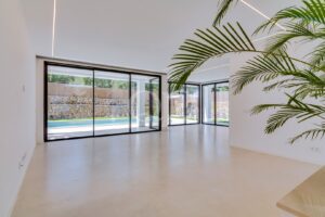 Open plan living area with floor to ceiling glazing and pool views