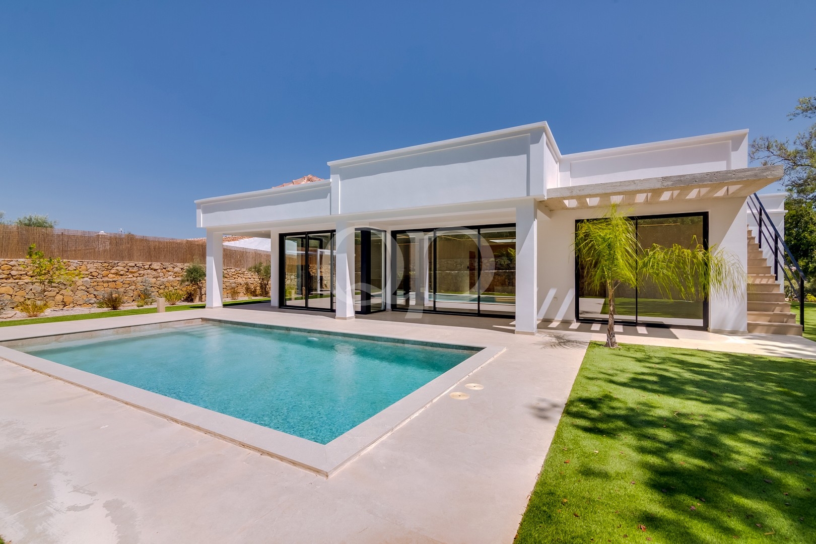 Moradia contemporânea com piscina, relvado e terraço coberto