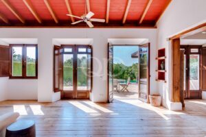 Wohnzimmer mit sichtbarer Holzdecke und Zugang zur Terrasse