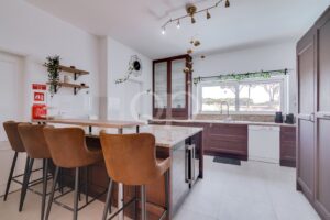 Elegante, geräumige Küche mit viel Licht, Marmor-Arbeitsplatten und einer Theke