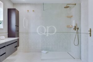 Helles, geräumiges Badezimmer mit begehbarer Glasdusche und elegantem Waschtisch