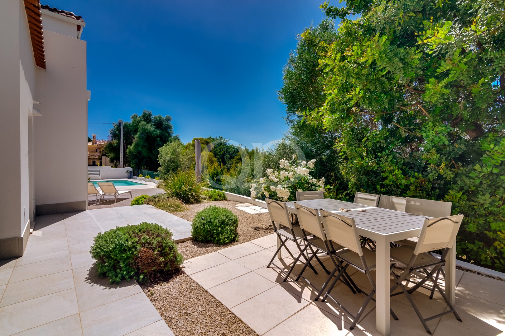 Poolterrasse mit Essbereich im Freien und gepflegten Gärten