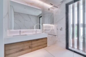 Salle de bains avec finitions en marbre, double vasque et douche à l'italienne