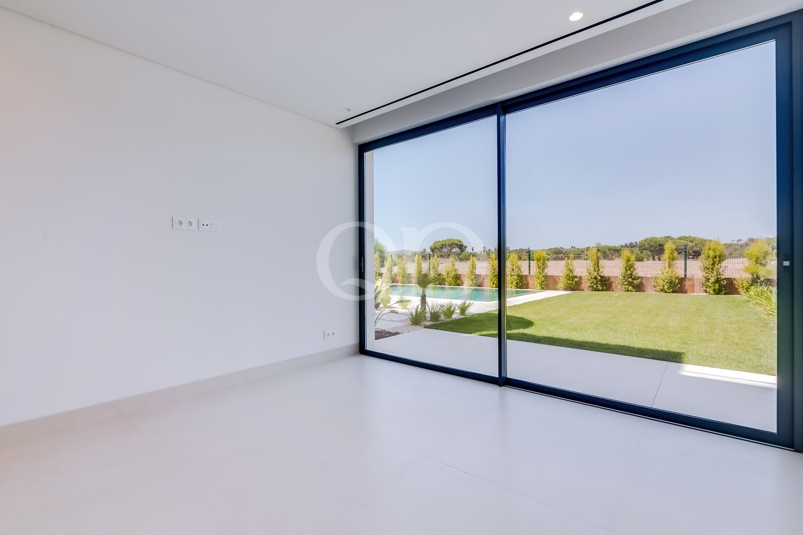 Chambre avec baies vitrées allant du sol au plafond et accès au jardin