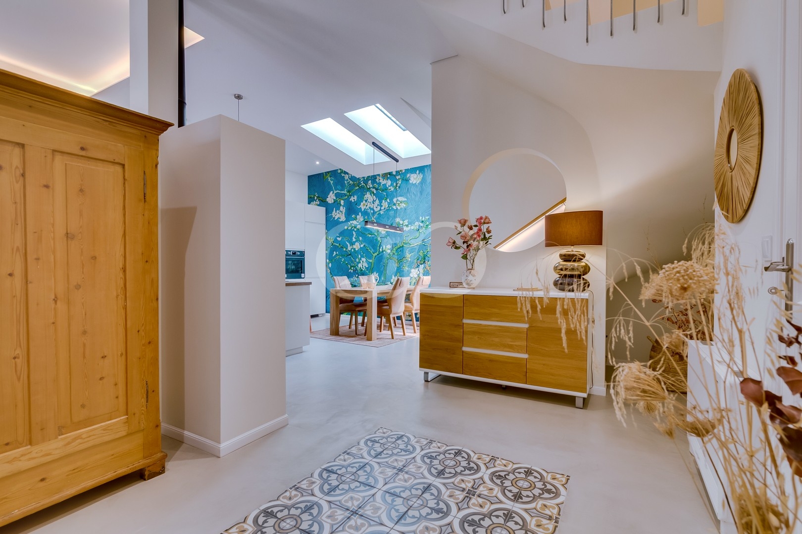 Bright, elegant entrance hall featuring contemporary furnishings, skylights, and distinctive patterned flooring