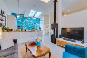Open plan living area with wood burning stove, skylights and feature wall