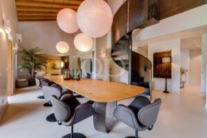 Sala de jantar espaçosa com uma escadaria de destaque e interiores contemporâneos