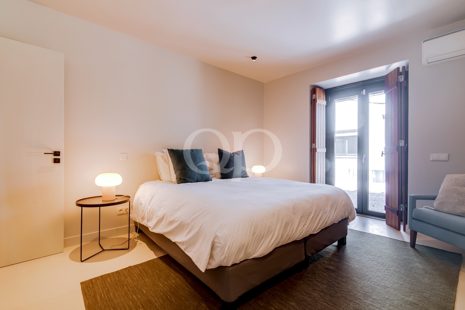 Quarto com decoração em tons neutros e acesso direto ao exterior