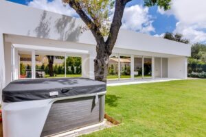 Reizendes Luxus-Ferienhaus mit gepflegtem Garten, altem Baumbestand und Essbereich im Freien.
