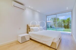 Bedroom with floor to ceiling glazing and garden views