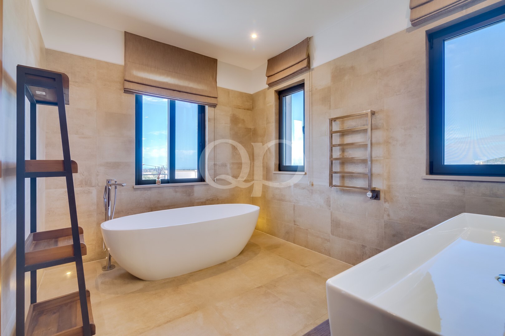 Badezimmer mit freistehender Badewanne und Fenstern mit Blick in zwei Richtungen