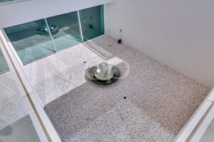 Innenhof mit dekorativem Wasserspiel und raumhoher Verglasung