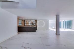 Offener Wohnbereich mit moderner Küche, Marmorboden und Zugang zur Terrasse