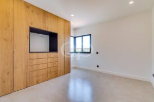 Bedroom with bespoke wooden storage, integrated television and countryside views