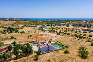 Aerial view of villa, private pool, countryside and distant sea