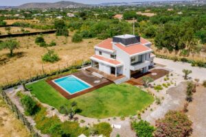 Aerial view of modern villa with private pool and landscaped grounds