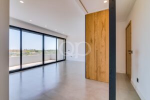 Contemporary interior with wooden feature cabinetry and large sliding windows