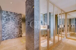 Walk in wardrobe with mirrored doors and natural stone detailing