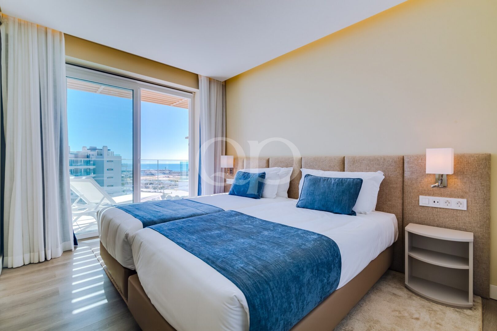 Chambre avec baie vitrée allant du sol au plafond et vue sur l'océan