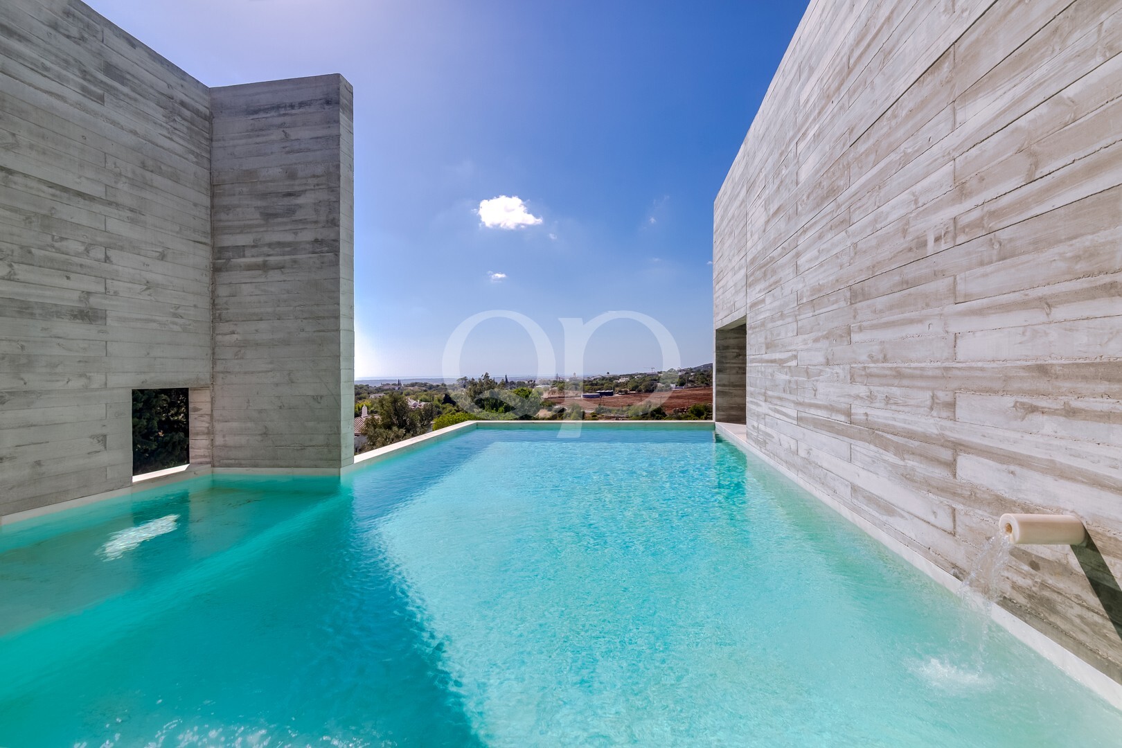 Striking private pool framed by contemporary stone architecture and open views