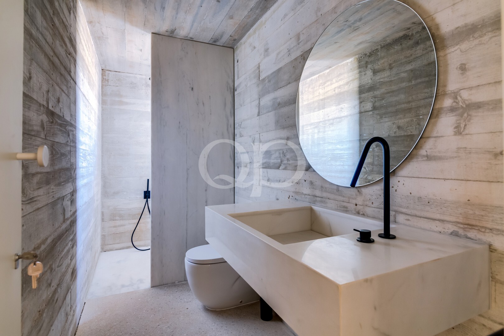 Une salle de bains élégante, dotée d'un lavabo sculptural, d'un miroir remarquable et de finitions raffinées en pierre