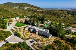 Vue aérienne en contre-plongée mettant en valeur la villa au cœur d'un magnifique cadre naturel