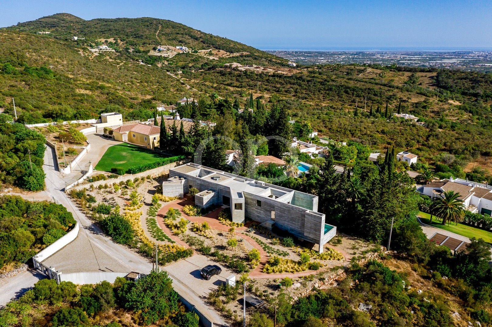 Vue aérienne en contre-plongée mettant en valeur la villa au cœur d'un magnifique cadre naturel