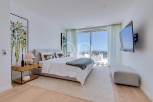Spacious bedroom with modern interiors and direct access to a private terrace.