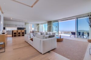Spacious open plan living area with contemporary furnishings and panoramic sea views.