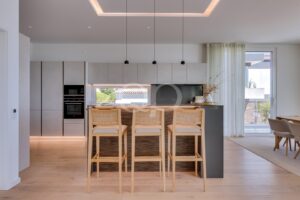 Modern villa kitchen with breakfast bar, integrated appliances and stylish minimalist finishes.
