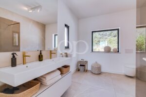 Casa de banho contemporânea em estilo spa, com lavatório duplo, cabina de duche e acabamentos naturais requintados