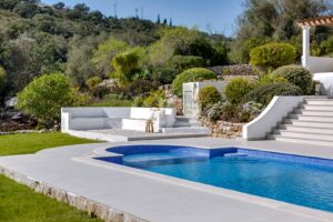 Terraço com piscina ajardinado, com vegetação mediterrânica madura, muros de pedra e um ambiente tranquilo na encosta