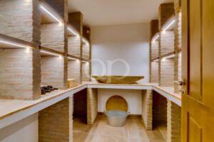 Cave à vin lumineuse et spacieuse, dotée de murs traditionnels en pierre naturelle