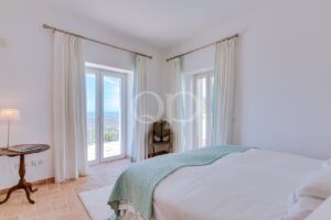 Chambre lumineuse et paisible, dotée d'un mobilier raffiné, de portes-fenêtres et d'une vue imprenable sur la mer
