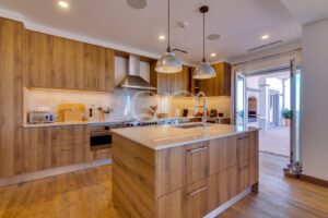 Cuisine contemporaine et spacieuse, dotée d'un parquet, d'armoires et d'un grand îlot en marbre