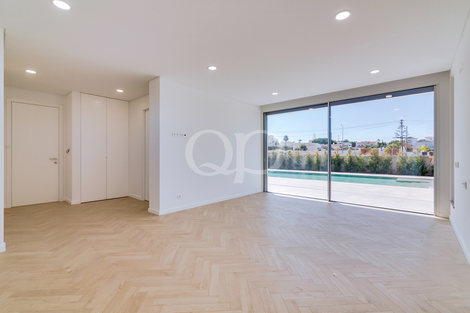 Quarto luminoso com grandes portas de correr que se abrem para a zona da piscina