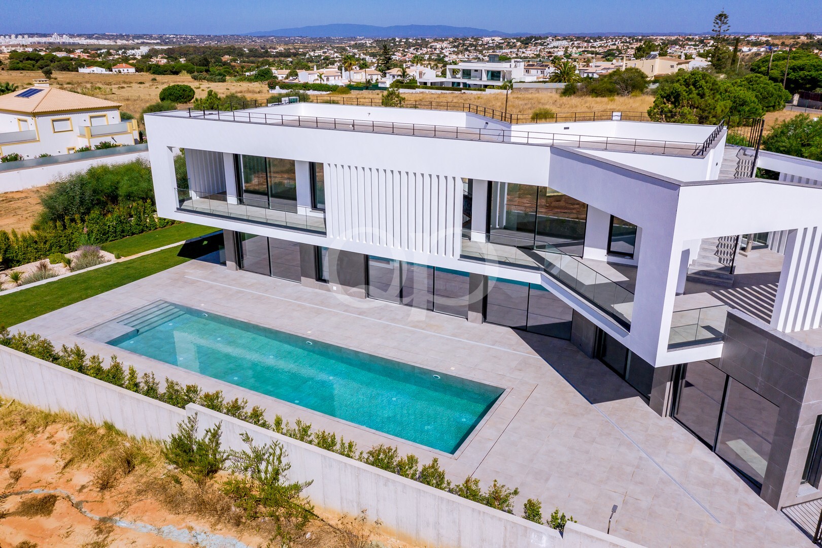 Vista aérea de uma moradia contemporânea, com piscina privada e terraços espaçosos
